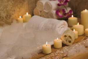 Apartments in Friedrich Wilderness Park NW San Antonio A luxurious bath tub adorned with fragrant flowers and flickering candlelight, creating a serene atmosphere. The delicate scent of the soap adds to the indulgent experience.