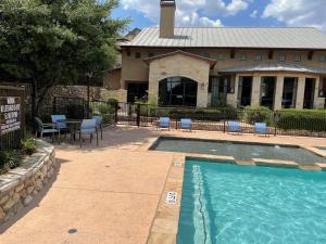 Apartments in San Antonio, Texas - Community Pool  Patio with Seating and Lounges - View to Clubhouse