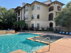 Apartments in San Antonio, TX - Swimming-Pool-and-Patio-Area-with-Apartment-Building-in-Background